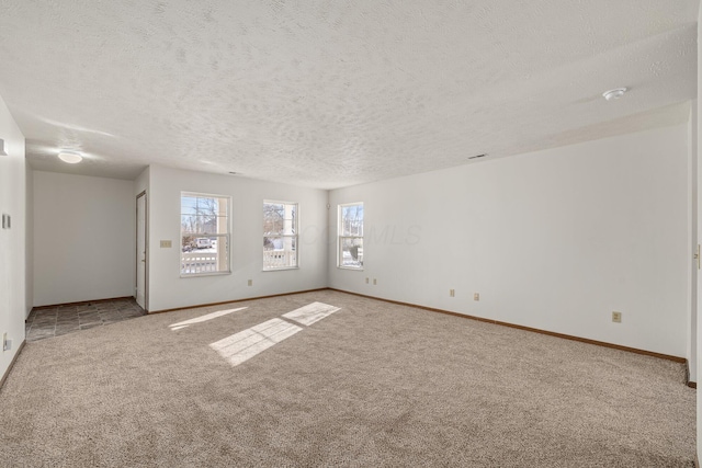 carpeted spare room featuring a textured ceiling