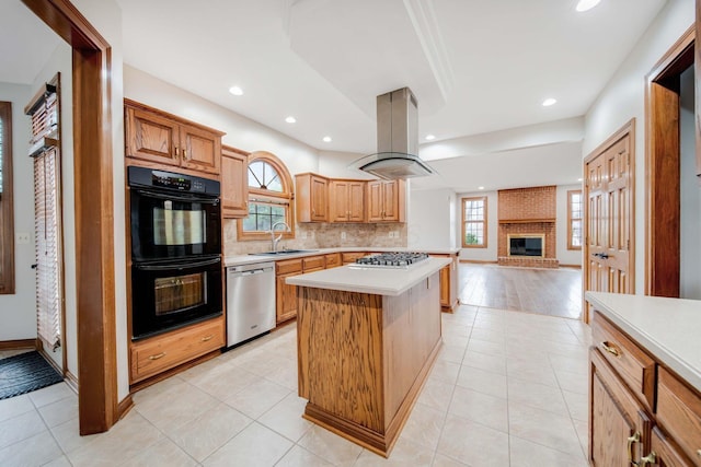 kitchen with a kitchen island, island range hood, sink, backsplash, and stainless steel appliances