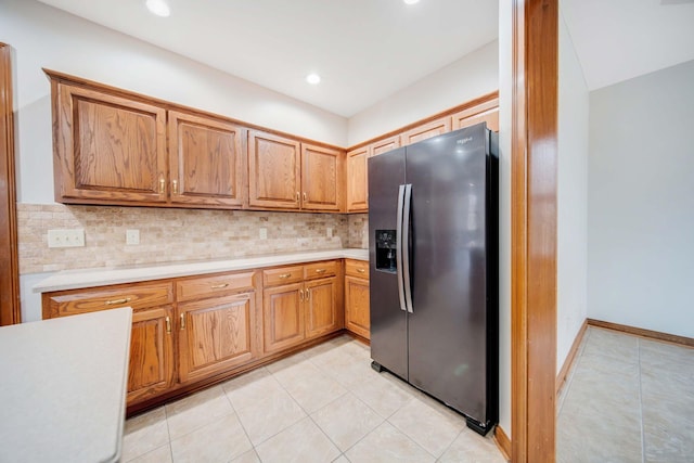 kitchen featuring light tile patterned floors, decorative backsplash, and stainless steel fridge