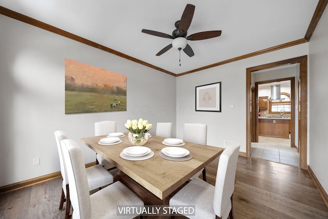 dining room featuring sink, crown molding, light hardwood / wood-style flooring, and ceiling fan