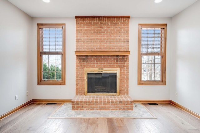 unfurnished living room featuring light wood-type flooring and a fireplace