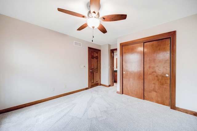 unfurnished bedroom with light carpet, a closet, and ceiling fan