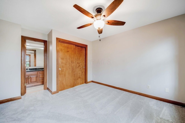 unfurnished bedroom with light carpet, a closet, and ceiling fan