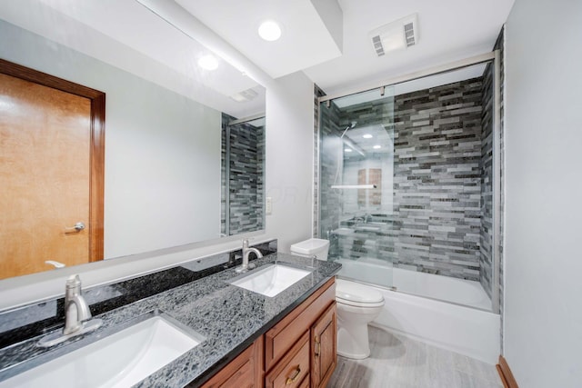 full bathroom featuring toilet, vanity, and shower / bath combination with glass door