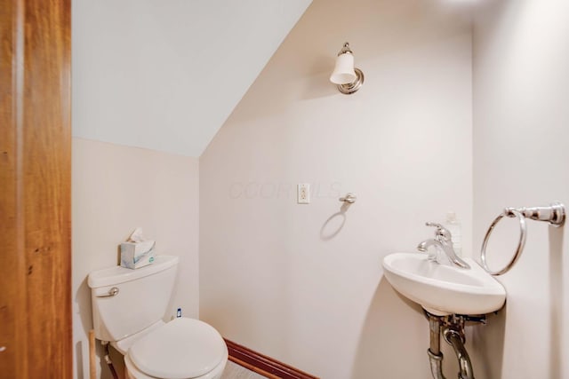 bathroom featuring lofted ceiling, sink, and toilet