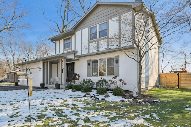 view of front of property with a garage, a lawn, and covered porch