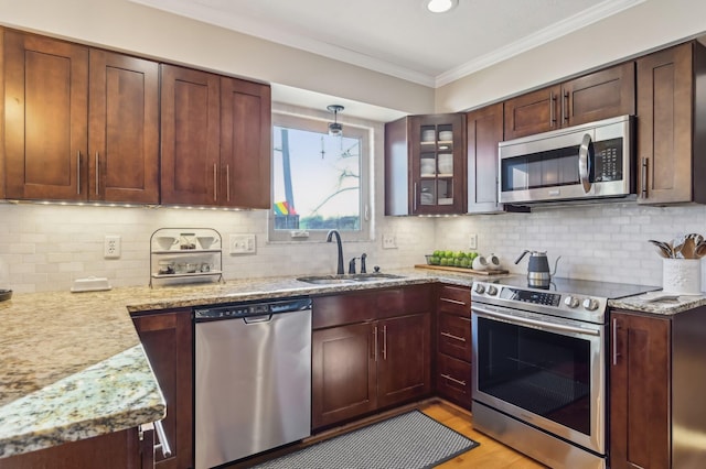 kitchen featuring sink, light stone counters, crown molding, light wood-type flooring, and stainless steel appliances