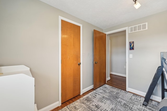 interior space featuring hardwood / wood-style flooring and a textured ceiling