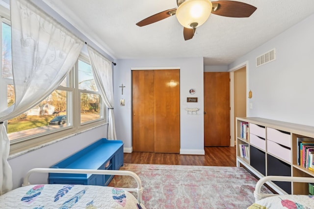 bedroom featuring a textured ceiling, wood-type flooring, and ceiling fan