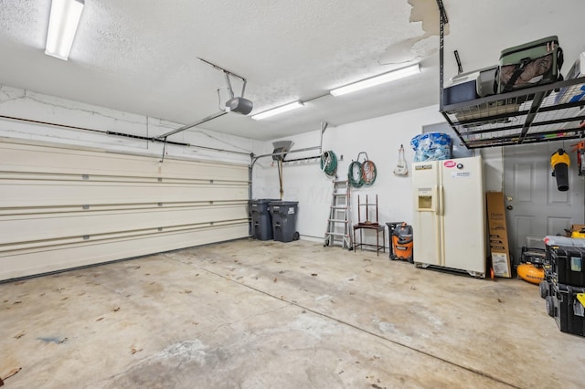 garage featuring a garage door opener and white refrigerator with ice dispenser