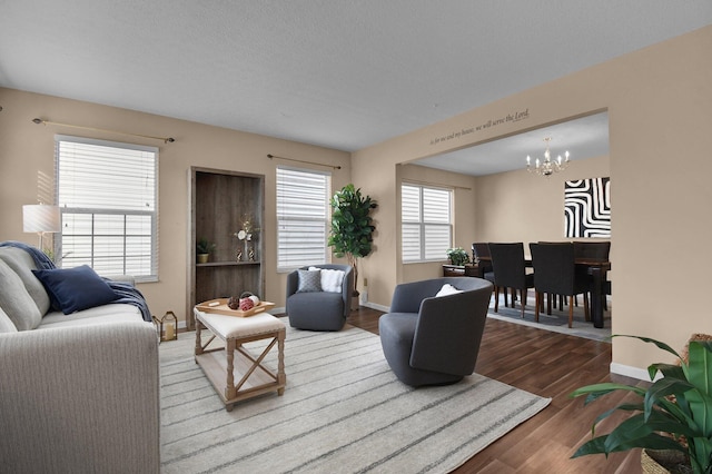 living room with wood-type flooring, a textured ceiling, and a chandelier