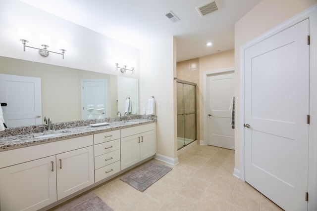 bathroom with tile patterned flooring, vanity, and a shower with shower door