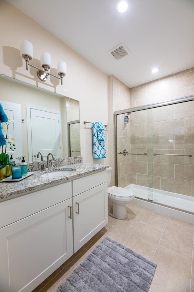 bathroom with vanity, an enclosed shower, tile patterned floors, and toilet