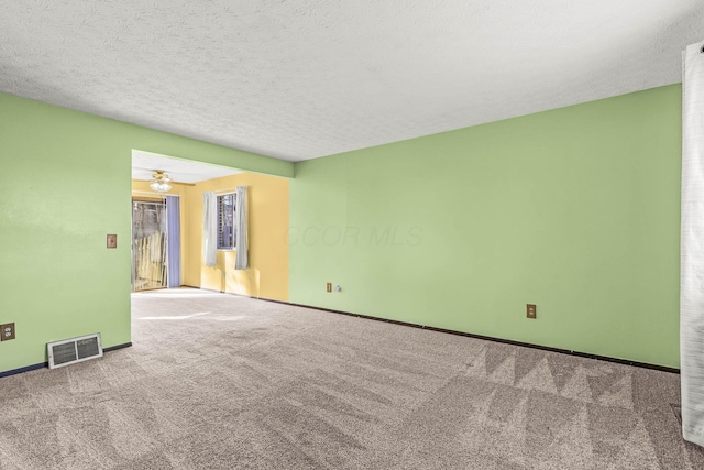 carpeted empty room featuring a textured ceiling