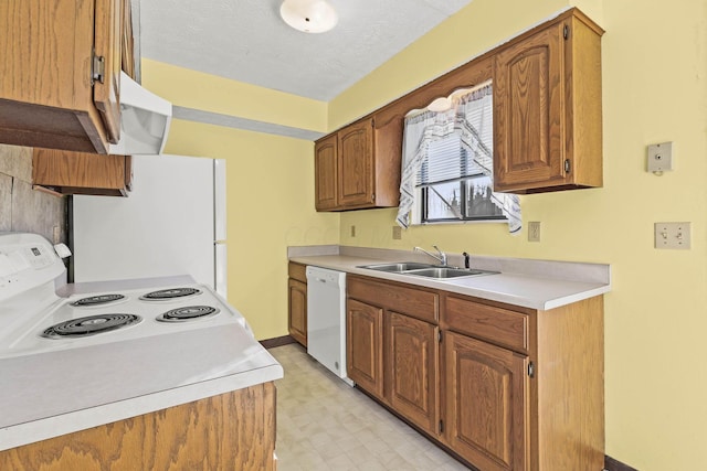 kitchen featuring sink, white appliances, and a textured ceiling