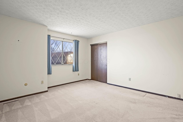 carpeted spare room with a textured ceiling