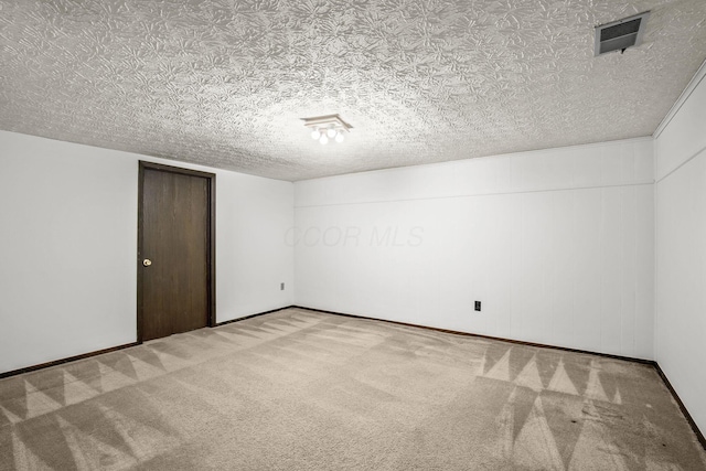 empty room with carpet flooring and a textured ceiling