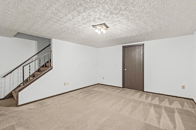 interior space with a textured ceiling and carpet flooring