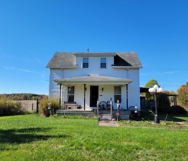 rear view of property with a porch and a lawn