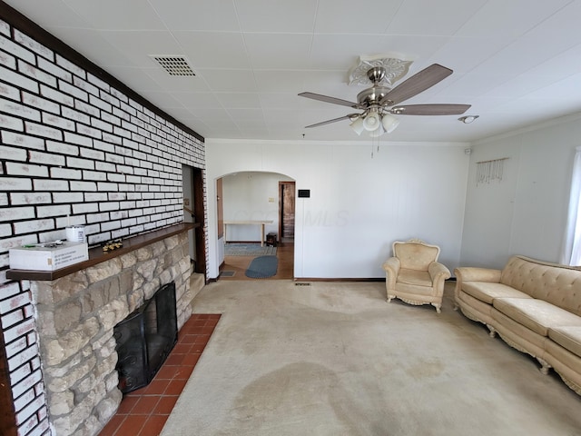 unfurnished living room with ornamental molding, ceiling fan, and a fireplace