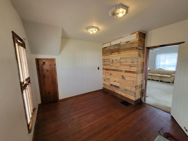 interior space featuring dark hardwood / wood-style flooring and wood walls