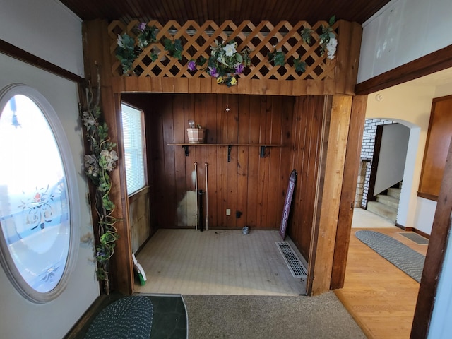 foyer entrance featuring wood walls