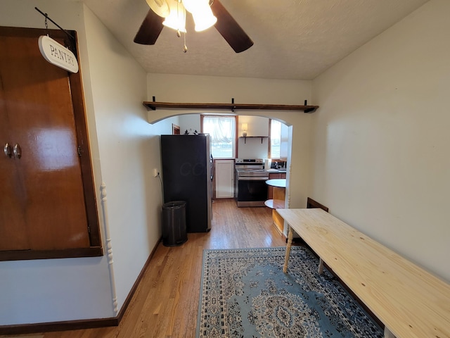 hallway featuring light hardwood / wood-style floors and a textured ceiling