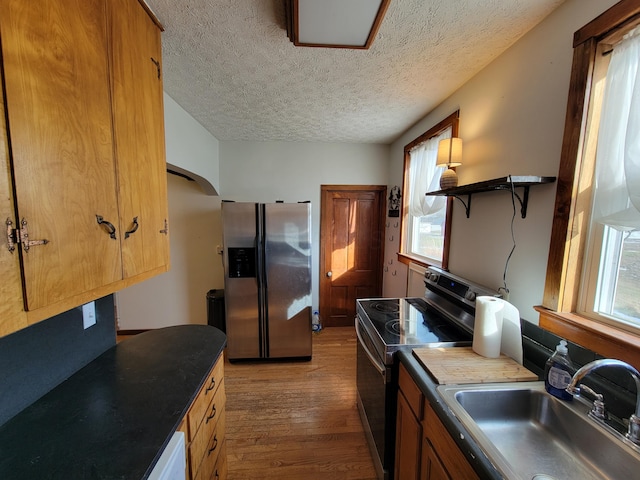 kitchen with sink, plenty of natural light, stainless steel appliances, and wood-type flooring