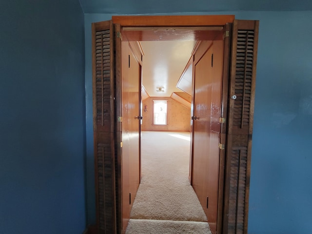 hall featuring vaulted ceiling and carpet