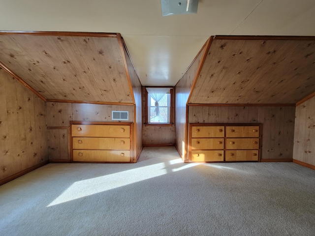 additional living space featuring lofted ceiling, light colored carpet, and wood walls