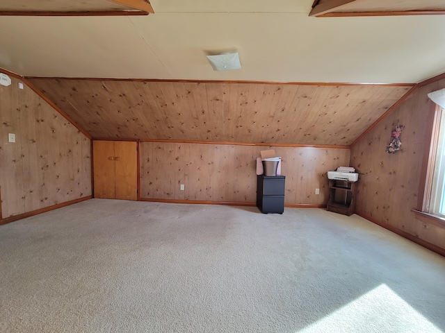 bonus room with lofted ceiling with beams, carpet flooring, and wood walls