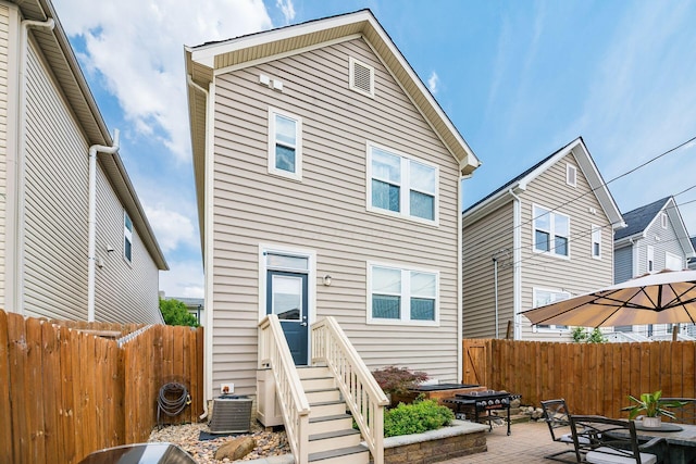 rear view of house with a patio and central AC