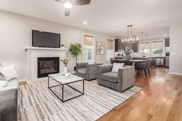 living room with light hardwood / wood-style floors and ceiling fan