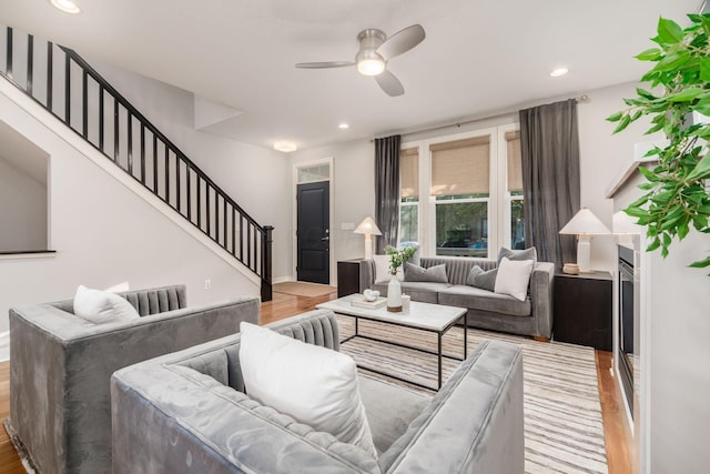 living room with ceiling fan and light hardwood / wood-style flooring