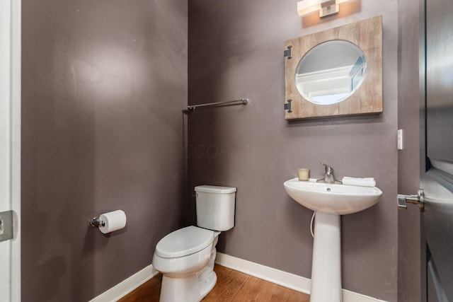 bathroom featuring hardwood / wood-style flooring and toilet