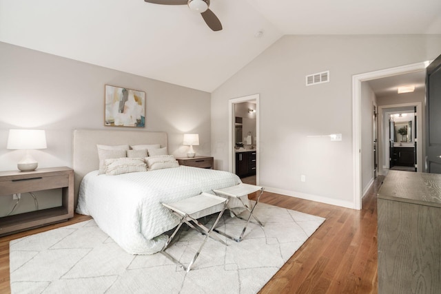 bedroom with hardwood / wood-style flooring, vaulted ceiling, ceiling fan, and ensuite bathroom