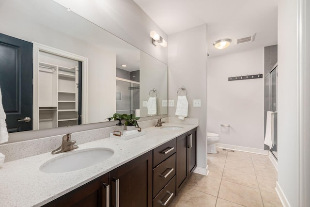 bathroom with vanity, toilet, tile patterned floors, and walk in shower