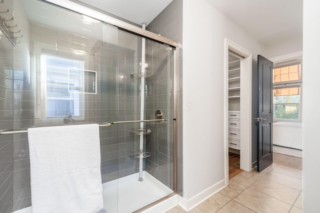 bathroom with a shower with shower door and tile patterned floors