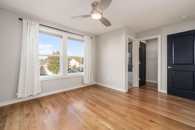 spare room with ceiling fan, wood-type flooring, and a wealth of natural light