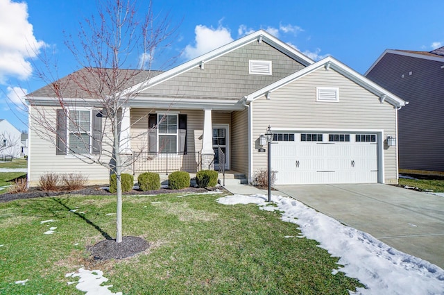 view of front of home featuring a porch, a garage, and a front lawn