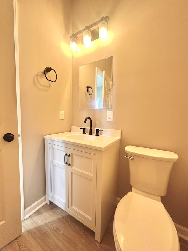 bathroom featuring vanity, hardwood / wood-style floors, and toilet