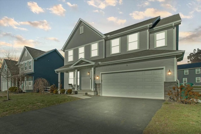 view of front of house featuring a garage and a front lawn