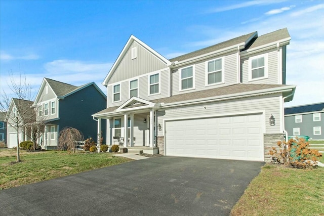 view of front facade with a garage, covered porch, and a front lawn