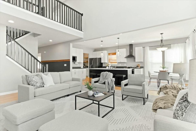 living room with light hardwood / wood-style flooring and a high ceiling