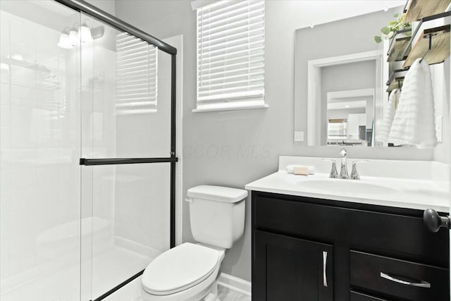 bathroom with walk in shower, vanity, and toilet