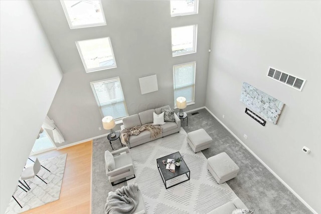 living room with a high ceiling and light wood-type flooring