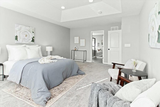 bedroom featuring light colored carpet and a tray ceiling