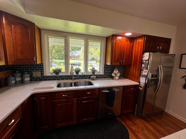 kitchen with sink, decorative backsplash, dark wood-type flooring, and appliances with stainless steel finishes