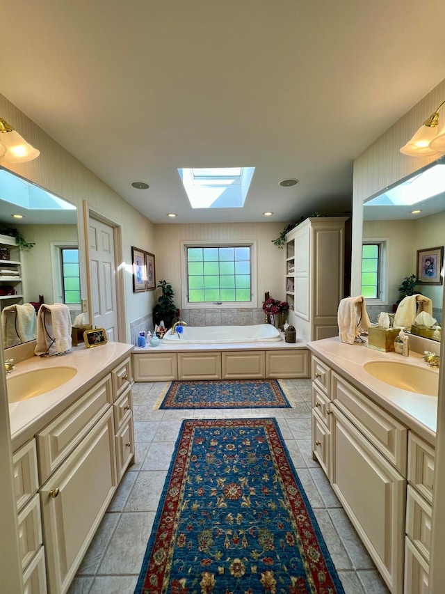 bathroom featuring a healthy amount of sunlight, vanity, a skylight, and a tub