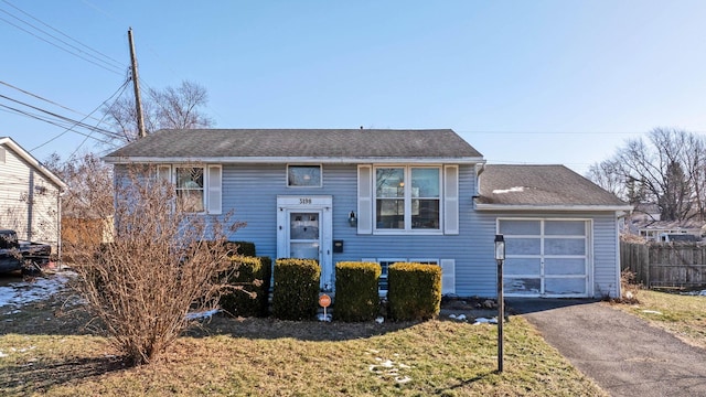 split foyer home with a garage and a front lawn